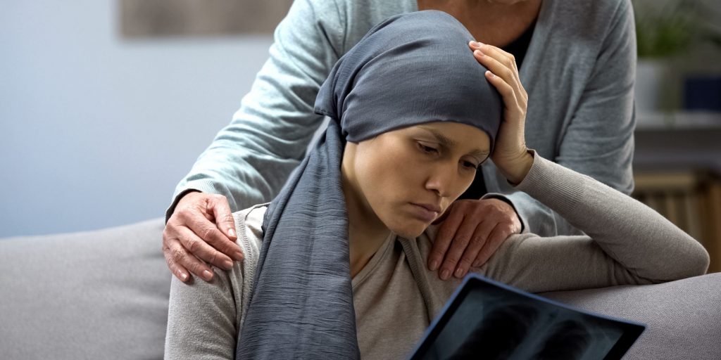 Woman with cancer looking at x-ray